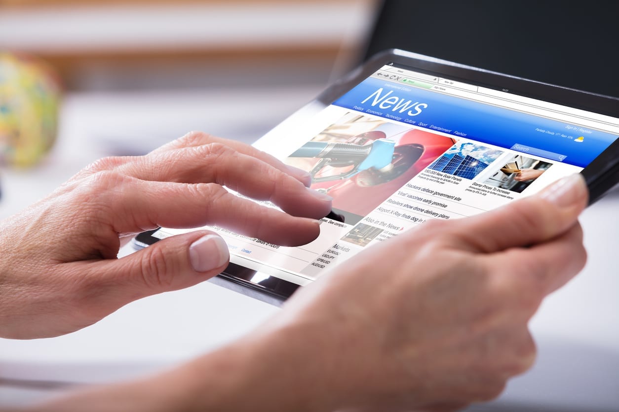 Close-up Of A Person's Hand Using Digital Tablet With Screen Showing Online News