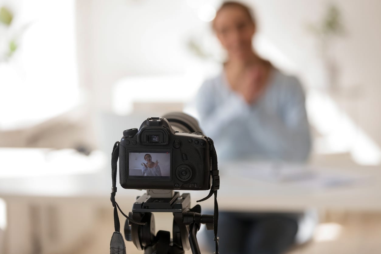 Businesswoman recording video blog on professional digital equipment, modern business coach making presentation for website or webinar, create content for video blog channel, focus on camera